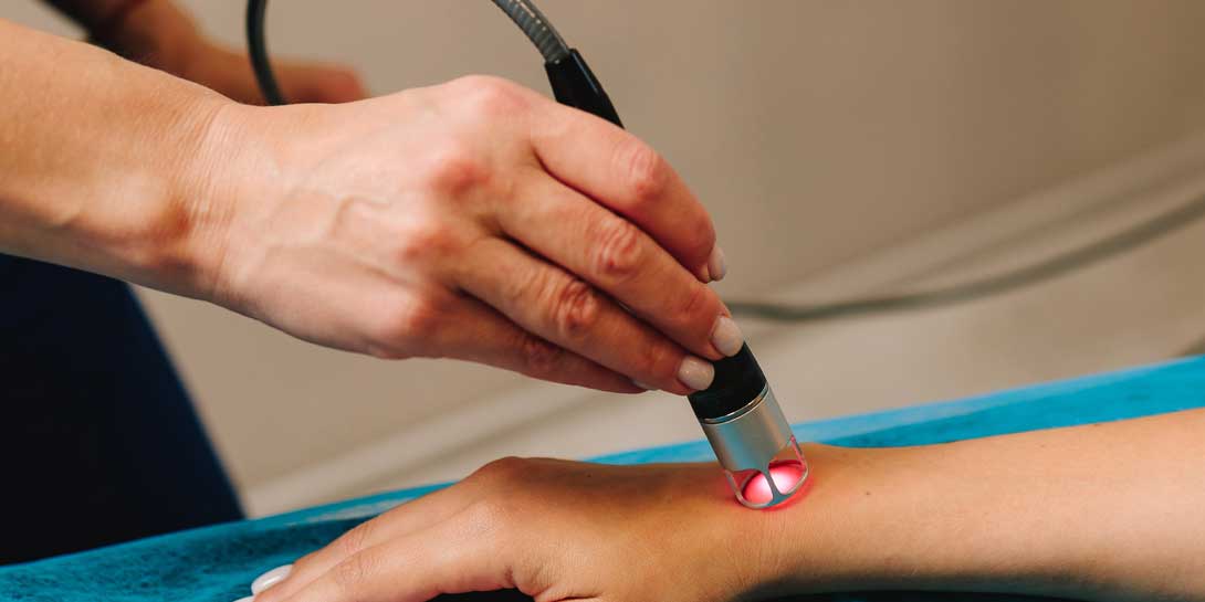 Infrared treatment of hand to manage pain, numbness and tingling. Doing laser therapy to improve blood flow and immune system. Hand low level laser therapy to promote healing of soft tissues